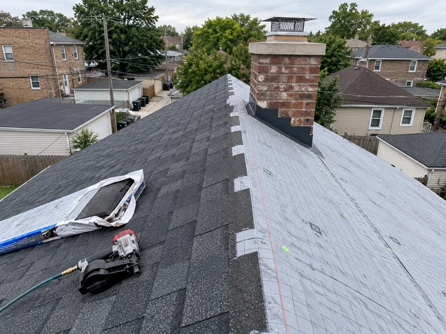 Roof mid-replacement: new shingles on one side, underlayment on the other